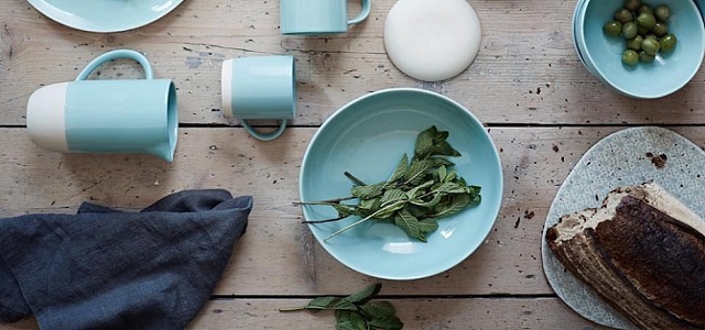 A set of light blue and white dishes and bowls on a wooden table.