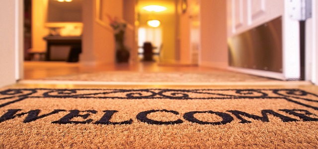 A Welcome Home floor mat at a front door.